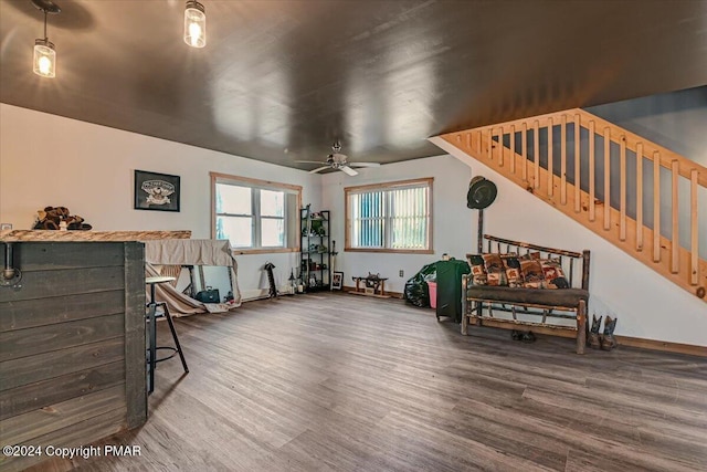 interior space featuring ceiling fan, wood finished floors, and baseboards