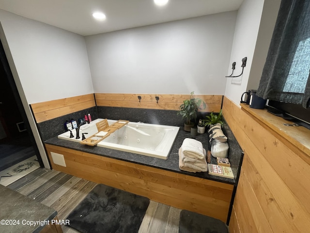 full bathroom featuring a tub with jets, wood finished floors, and recessed lighting