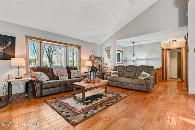 living area featuring high vaulted ceiling and light wood-style flooring