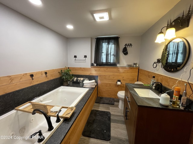 bathroom with a wainscoted wall, toilet, wood walls, vanity, and wood finished floors