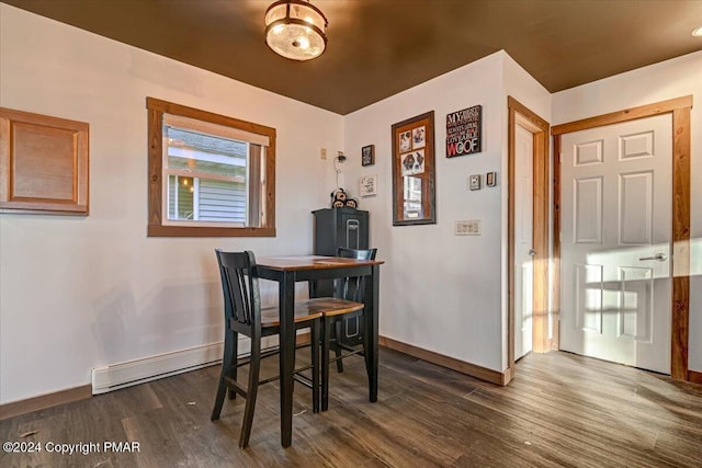 dining space with dark wood-type flooring, a baseboard radiator, and baseboards