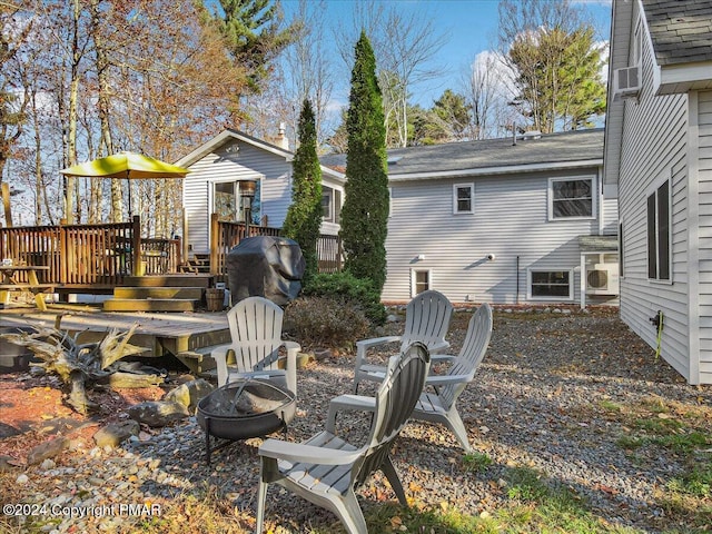 exterior space with a fire pit and a wooden deck