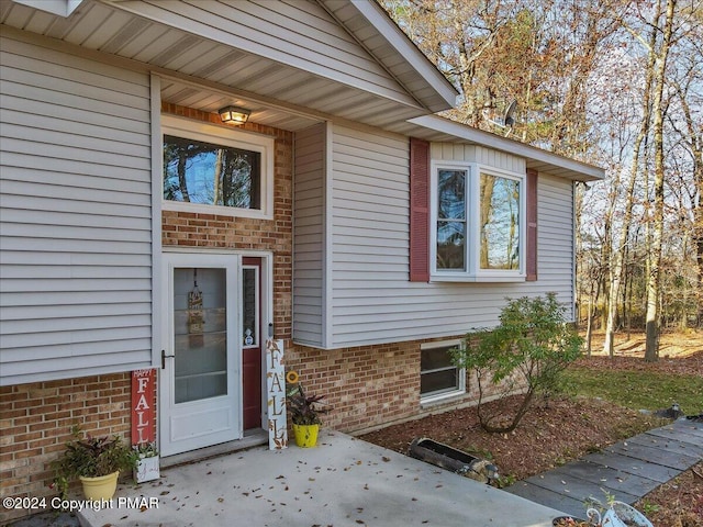 view of exterior entry featuring brick siding