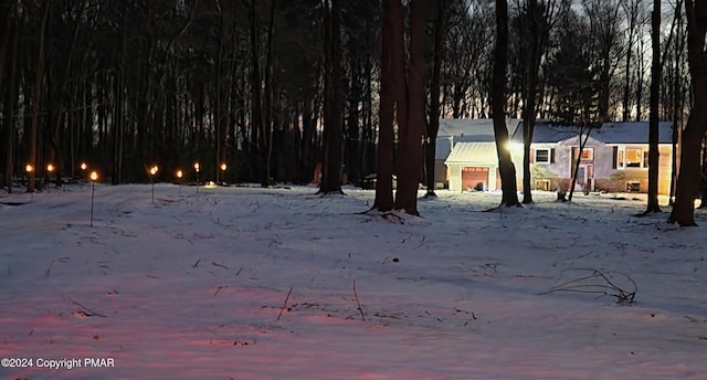 yard covered in snow featuring a garage