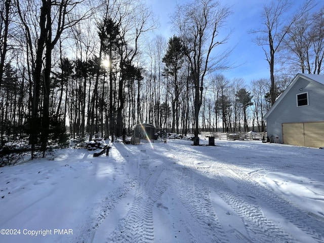 yard covered in snow featuring a detached garage