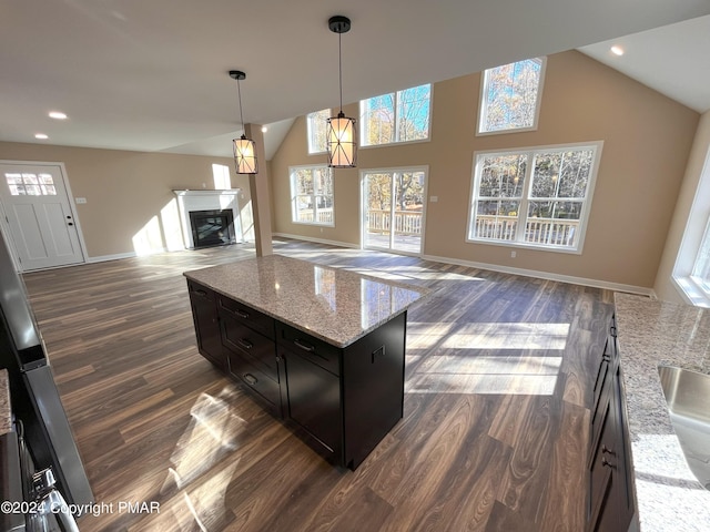 kitchen featuring baseboards, vaulted ceiling, a healthy amount of sunlight, and dark wood-style flooring