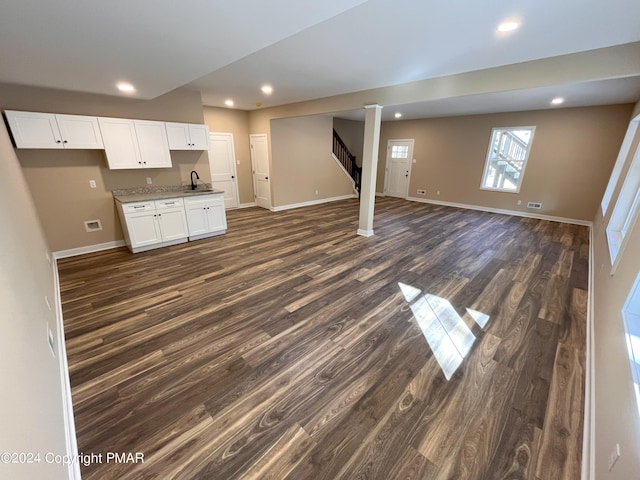 interior space with a sink, dark wood finished floors, baseboards, recessed lighting, and stairway