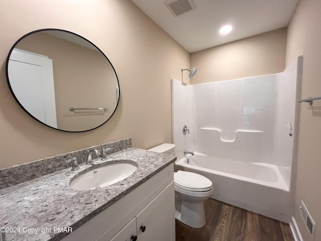 bathroom with wood finished floors, vanity, bathtub / shower combination, toilet, and visible vents
