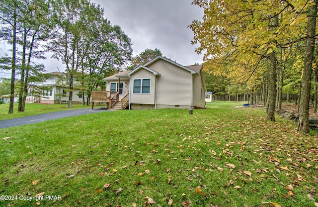 view of front of property with a front lawn, crawl space, and aphalt driveway