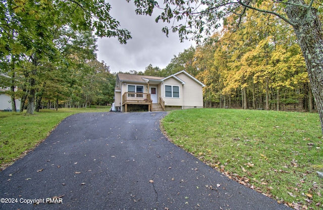 view of front of house featuring driveway, crawl space, and a front lawn