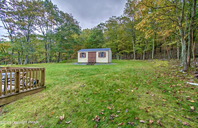 view of yard with an outdoor structure and a view of trees