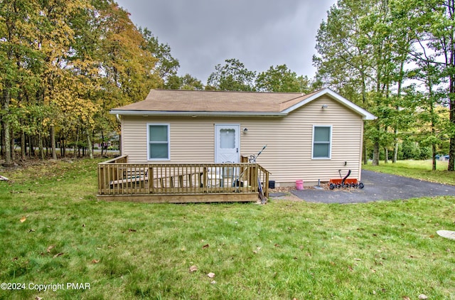 rear view of house with a deck and a lawn