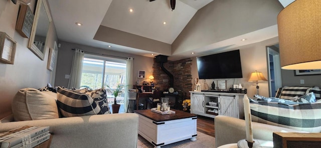 living room with a wood stove, recessed lighting, wood finished floors, and high vaulted ceiling