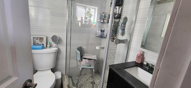 full bath with vanity, tile walls, toilet, and a stall shower