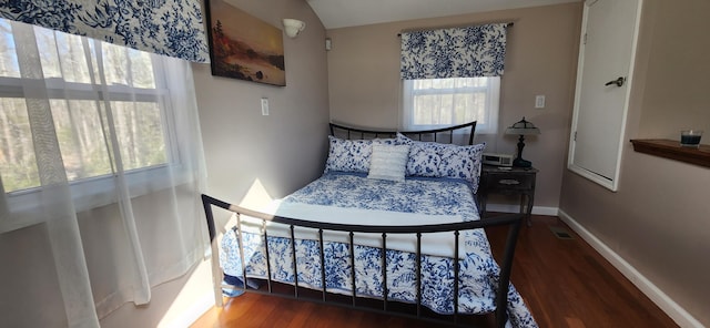 bedroom featuring visible vents, baseboards, and wood finished floors