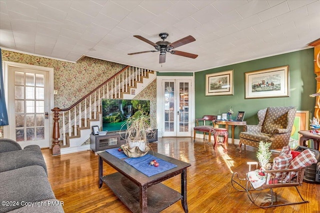 living area featuring wallpapered walls, baseboards, wood finished floors, stairs, and french doors