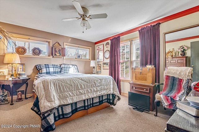 carpeted bedroom featuring ceiling fan, multiple windows, and baseboards