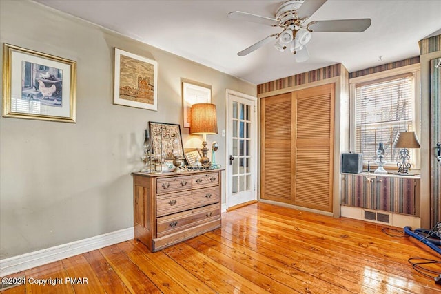 interior space with ceiling fan, light wood finished floors, visible vents, and baseboards