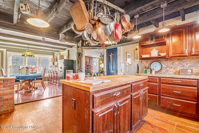 kitchen with light wood-style flooring, butcher block countertops, tasteful backsplash, and beamed ceiling