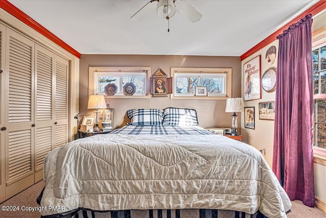 bedroom with a ceiling fan, a closet, carpet flooring, and multiple windows