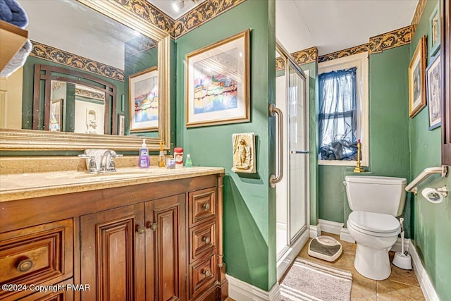 bathroom featuring tile patterned flooring, toilet, vanity, baseboards, and a shower stall