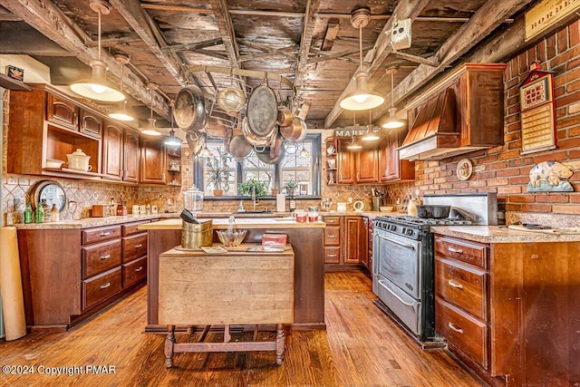 kitchen featuring a center island, open shelves, light countertops, and gas stove