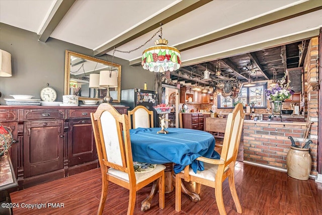 dining room featuring beamed ceiling and wood finished floors