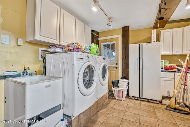 clothes washing area featuring cabinet space, washing machine and dryer, rail lighting, and light tile patterned flooring