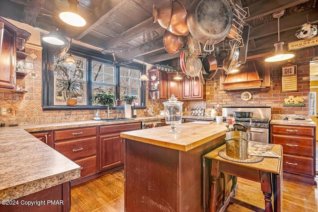 kitchen with open shelves, wooden counters, a kitchen island, a sink, and beamed ceiling