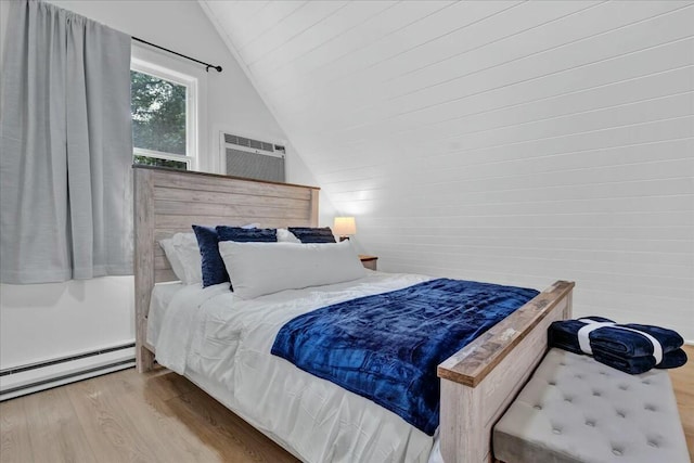 bedroom featuring a baseboard radiator, a wall mounted AC, lofted ceiling, and wood finished floors