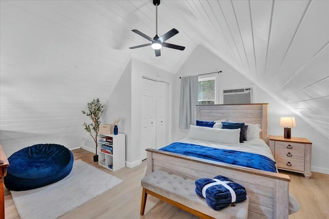 bedroom featuring light wood-style floors, vaulted ceiling, ceiling fan, and a wall mounted AC