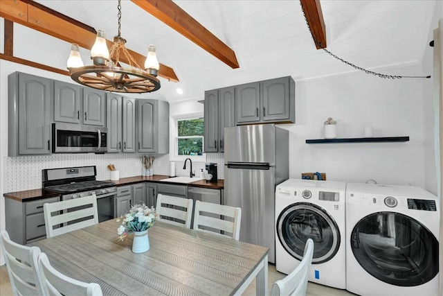 laundry area featuring a chandelier, laundry area, a sink, and washer and clothes dryer