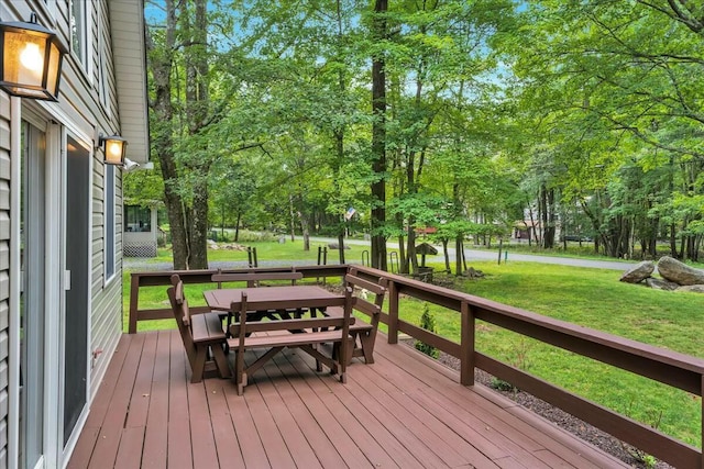 deck with outdoor dining area and a lawn