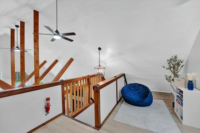 interior space featuring vaulted ceiling, wood finished floors, an upstairs landing, and a notable chandelier