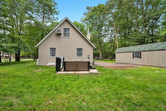 back of property featuring a jacuzzi, a chimney, an AC wall unit, and a yard