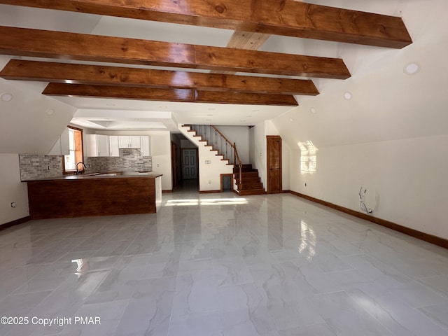 interior space featuring lofted ceiling with beams, marble finish floor, stairs, and baseboards