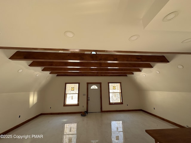 additional living space with vaulted ceiling with beams and baseboards