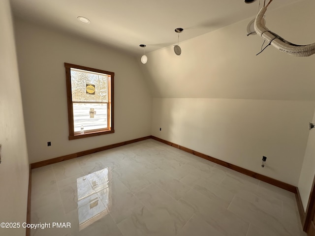 bonus room with lofted ceiling and baseboards