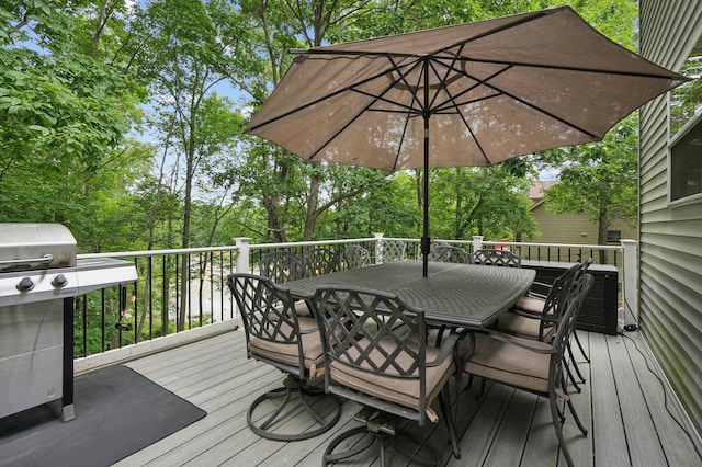 wooden deck featuring outdoor dining area and a grill