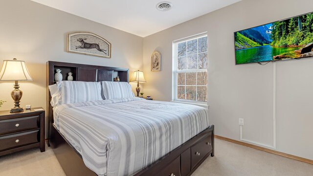 bedroom featuring visible vents, light colored carpet, and baseboards