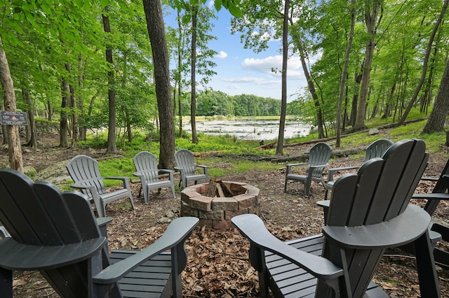 exterior space with a water view and an outdoor fire pit