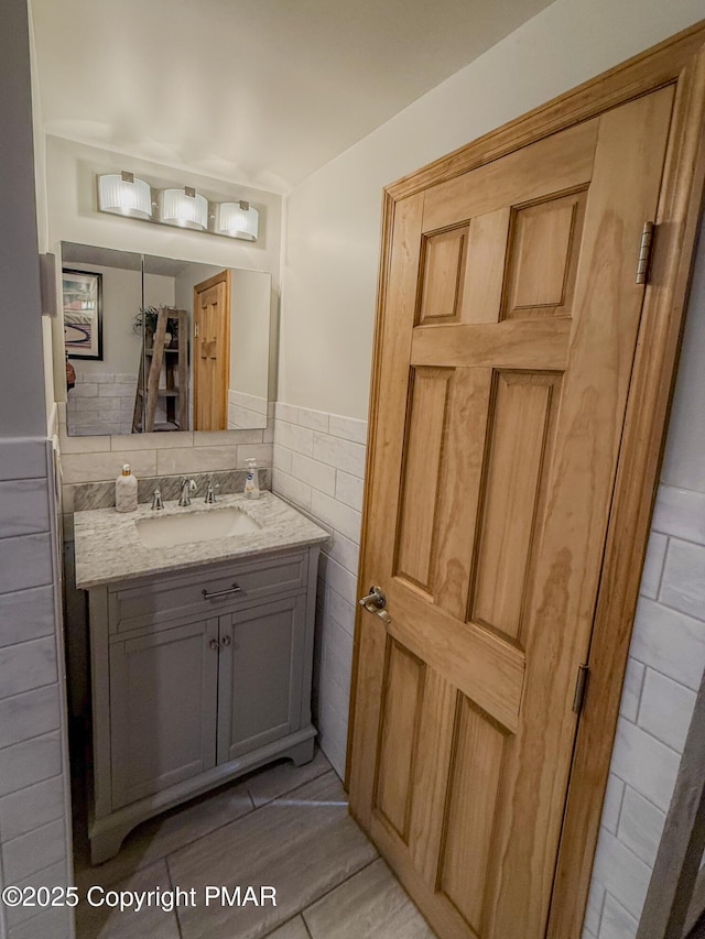 bathroom with vanity and tile walls