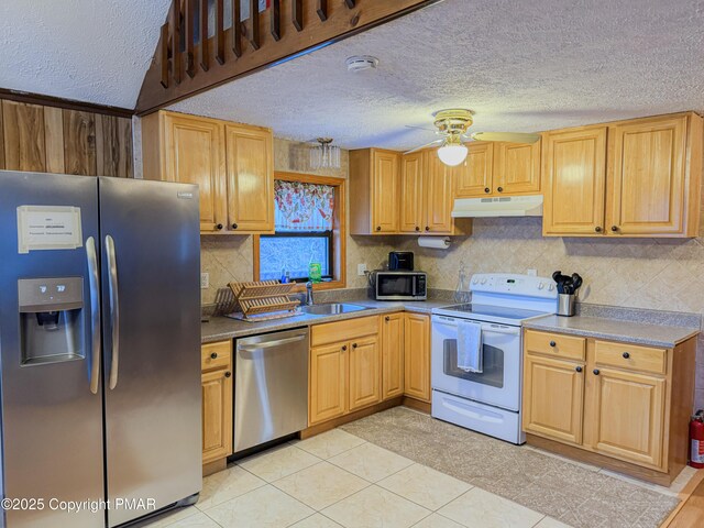 kitchen featuring sink, a textured ceiling, appliances with stainless steel finishes, ceiling fan, and backsplash