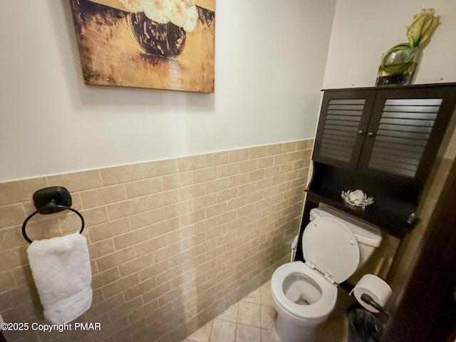 bathroom with tile walls, tile patterned floors, and toilet