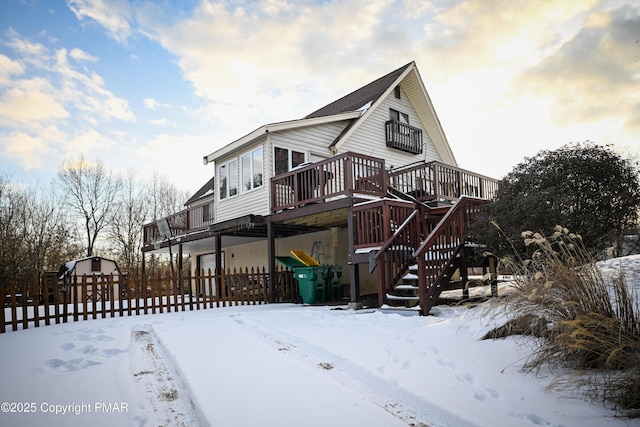 view of front of property featuring stairs, a wooden deck, and fence