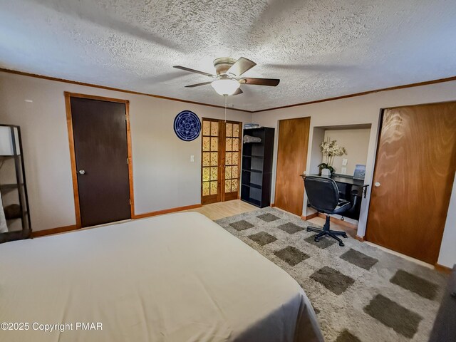 bedroom featuring hardwood / wood-style floors, ceiling fan, crown molding, a textured ceiling, and french doors