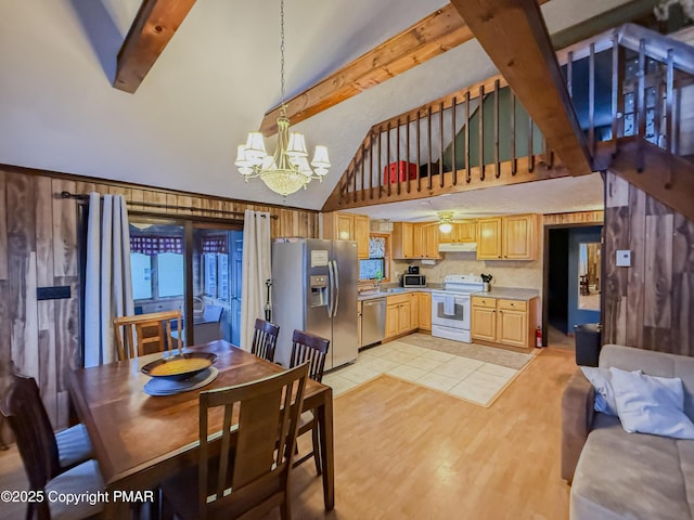 dining room featuring an inviting chandelier, high vaulted ceiling, wooden walls, beamed ceiling, and light wood-type flooring