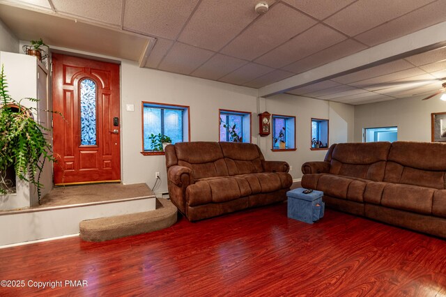 living room featuring hardwood / wood-style flooring, baseboard heating, and a drop ceiling