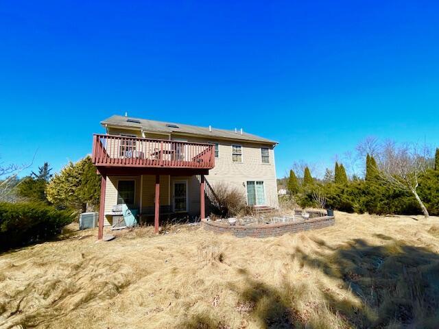 back of house with central AC unit and a wooden deck