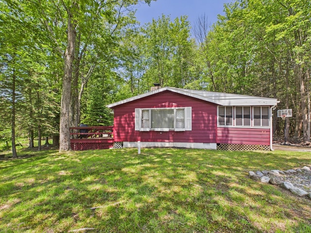 105 Buffalo Trl, Pocono Lake, PA 18347 - view of front facade featuring crawl space, a deck, a front yard, and a sunroom